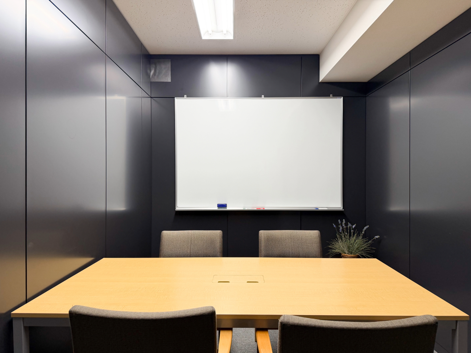 相談室の正面。テーブル、椅子、ホワイトボードがある部屋